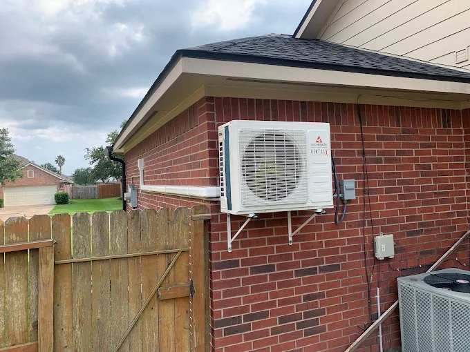Wall mounted mini split condenser on brick exterior wall in Pflugerville