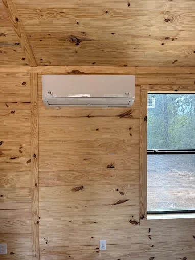 Indoor wall-mounted ductless mini split air handler in wooden interior room in Spring