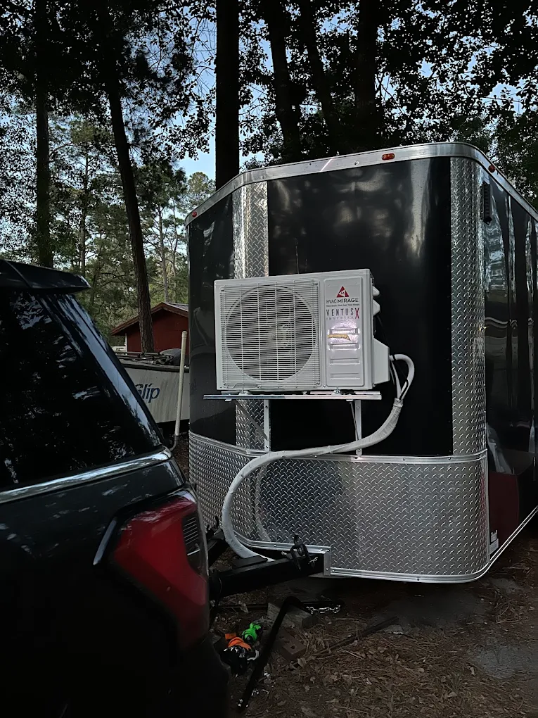 Ductless mini split condenser unit installed on enclosed trailer exterior in Cypress area