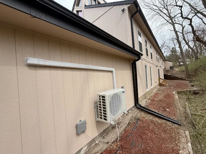 Wall-mounted outdoor mini split condenser with clean line hide cover in Round Rock
