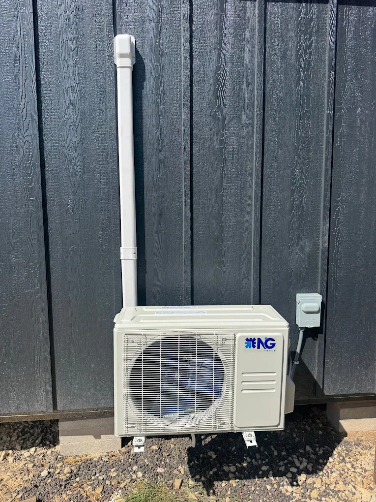 Wall-mounted outdoor mini split condenser on dark vertical siding in Cedar Park, TX