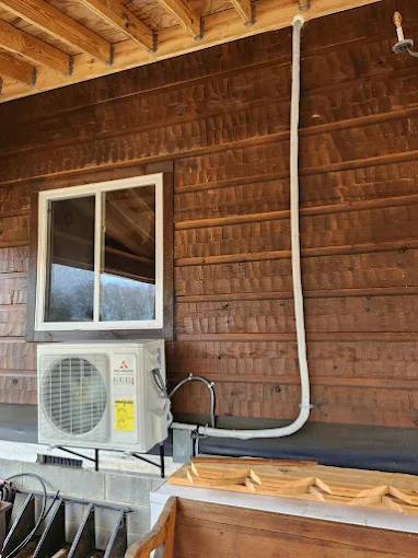 Wall-mounted mini split condenser on wood siding exterior in Georgetown