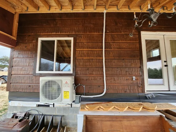 Ductless heat pump condenser installed on wood exterior wall in New Braunfels