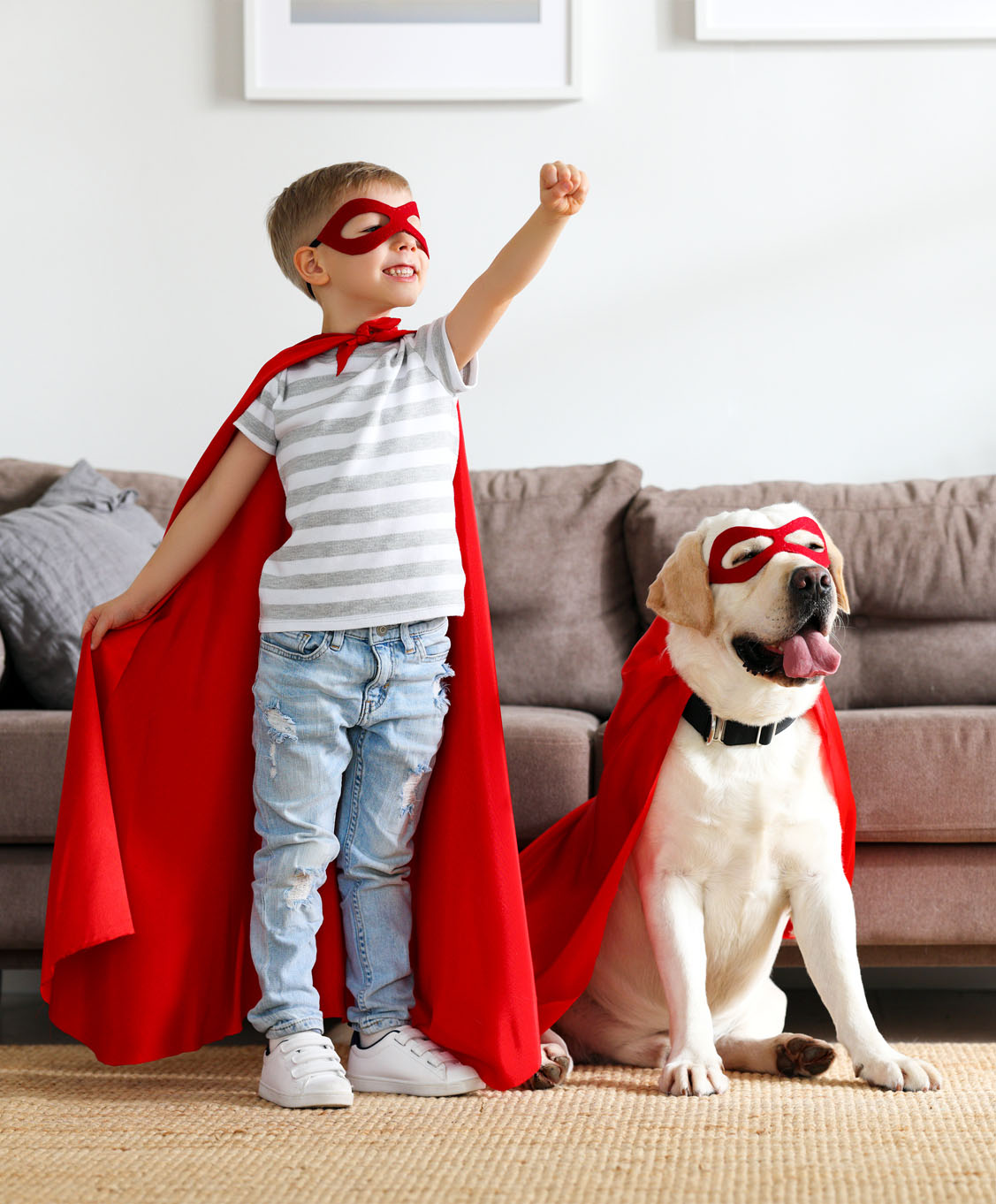 Boy in superhero cape with labrador