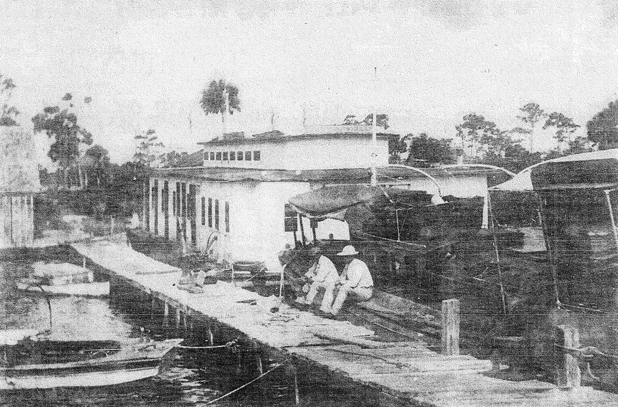 Historic photograph of docks, boats, and activity along the early Naples waterfront