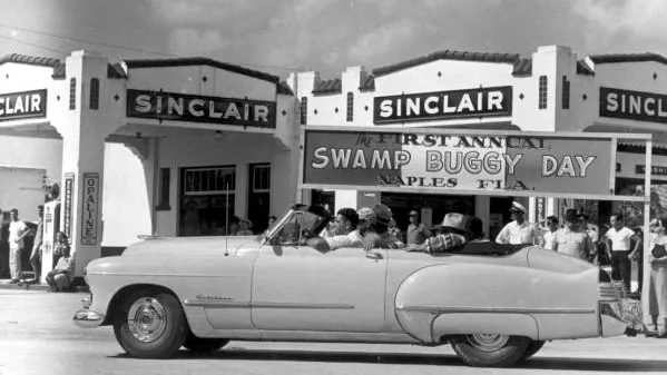 Historic Swamp Buggy Day parade in Naples, Florida, passing a Sinclair service station