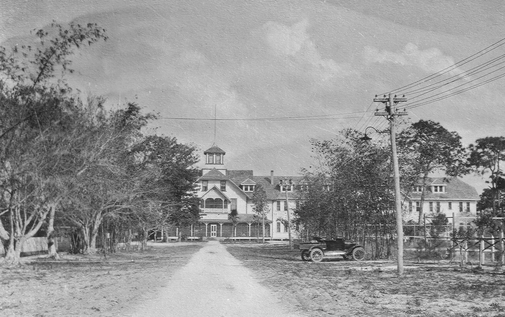 Historic Naples, Florida in 1925 with an early roadway, historic building, and automobile