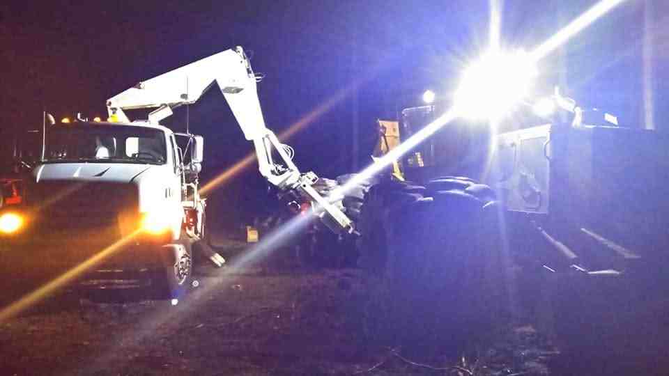 Night time mobile repair operation with crane truck servicing equipment