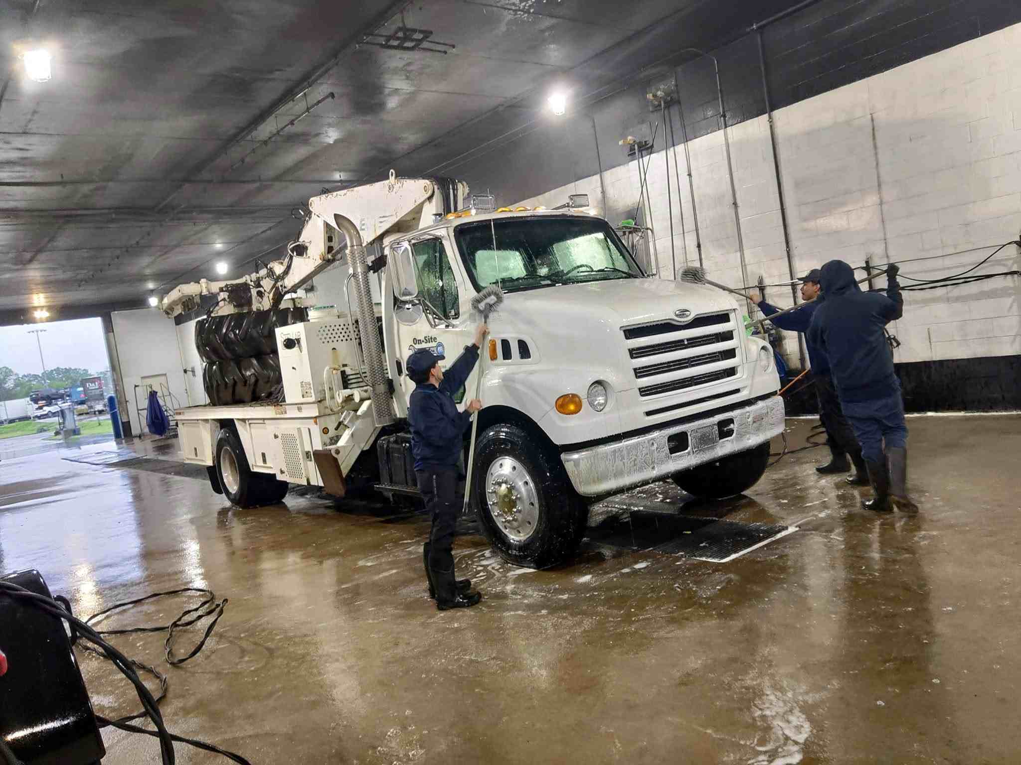 Team washing and maintaining On-Site Auto service truck in the shop