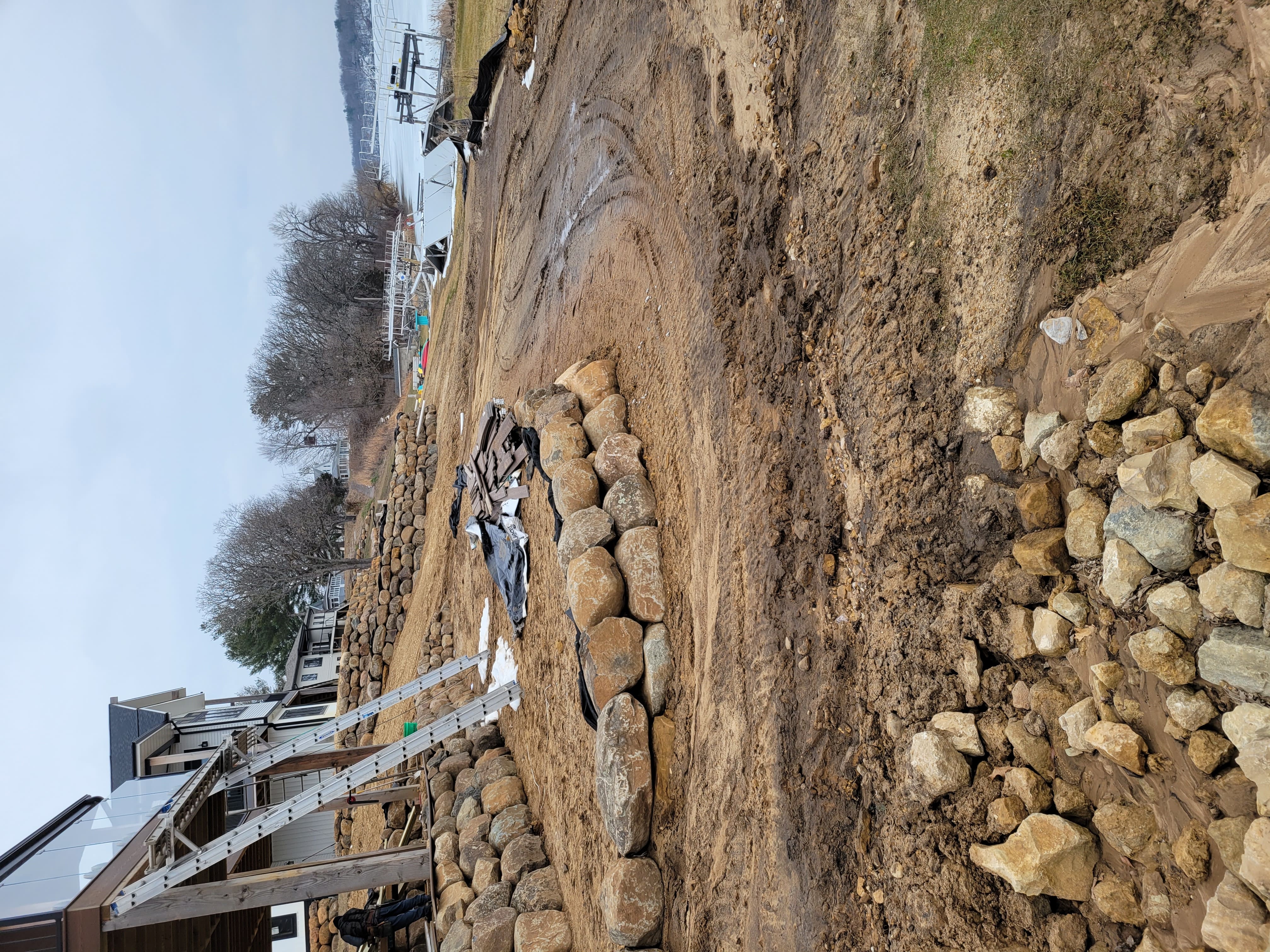 Grading and boulder retaining wall construction along sloped lakeside yard in Dane County, WI