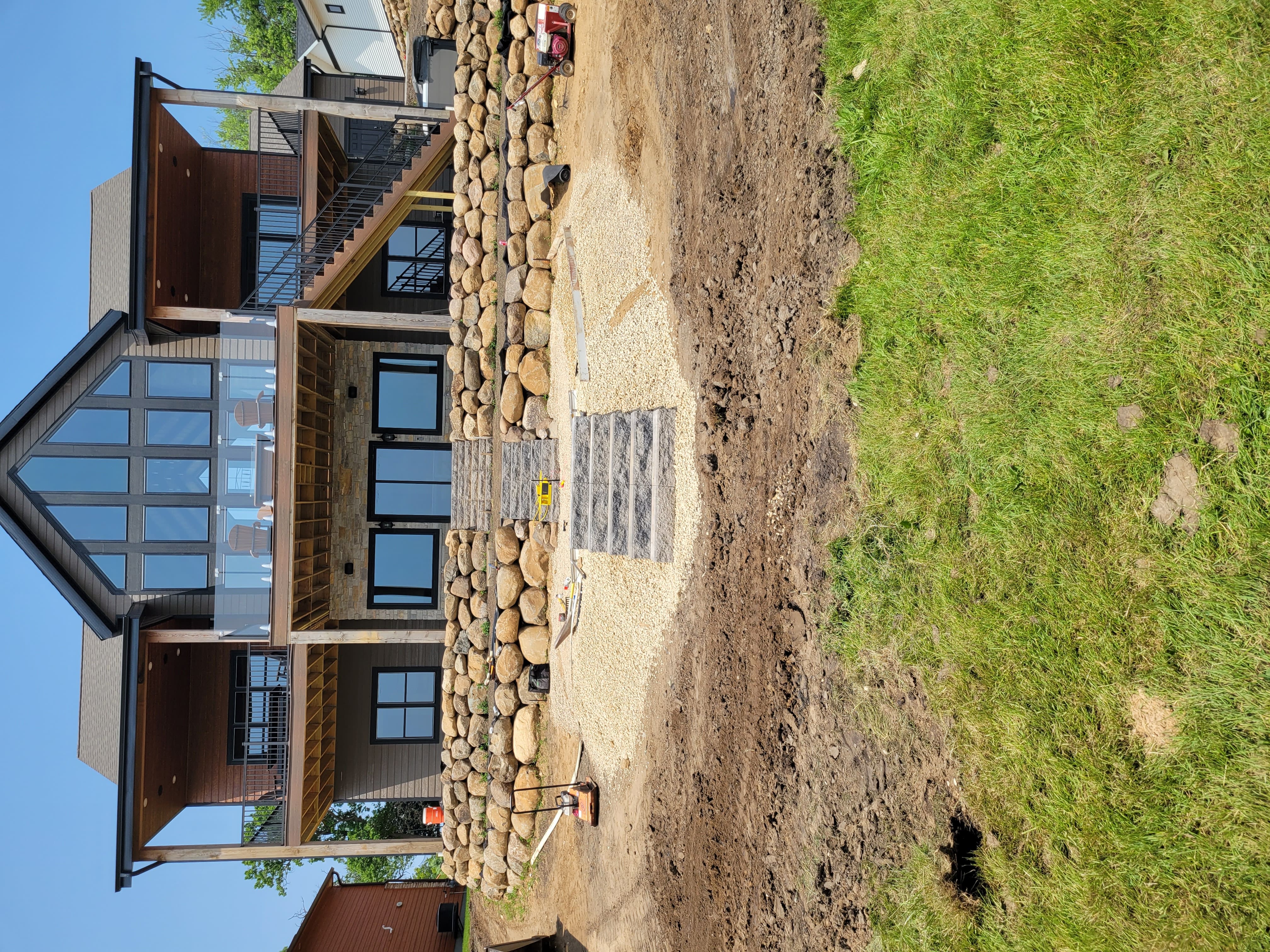 Boulder retaining wall with paver step and gravel patio installation in Dane County, WI