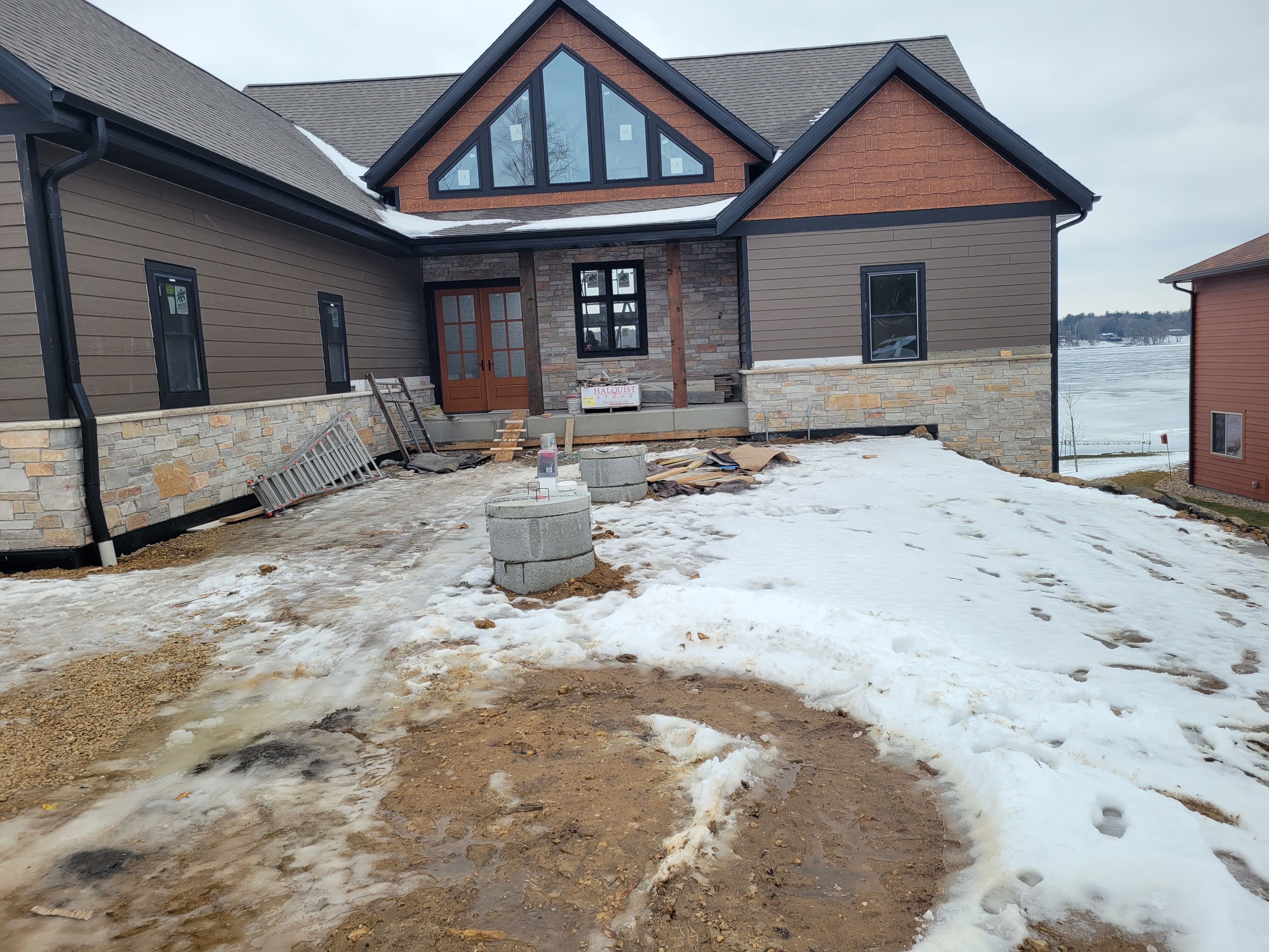 Lakeside home construction site with stone foundation ready for retaining wall landscaping in Dane County, WI