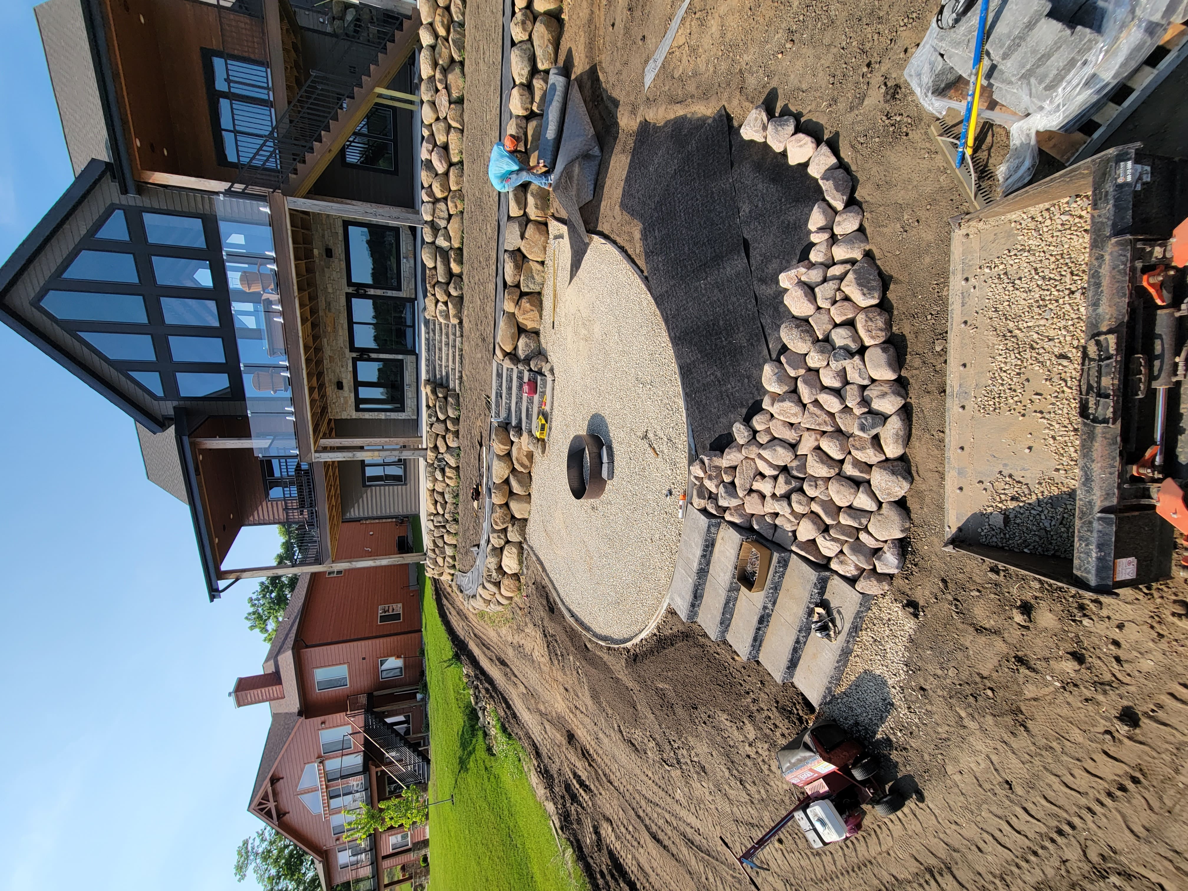 Boulder retaining wall with paver patio and fire pit installation in Dane County, WI