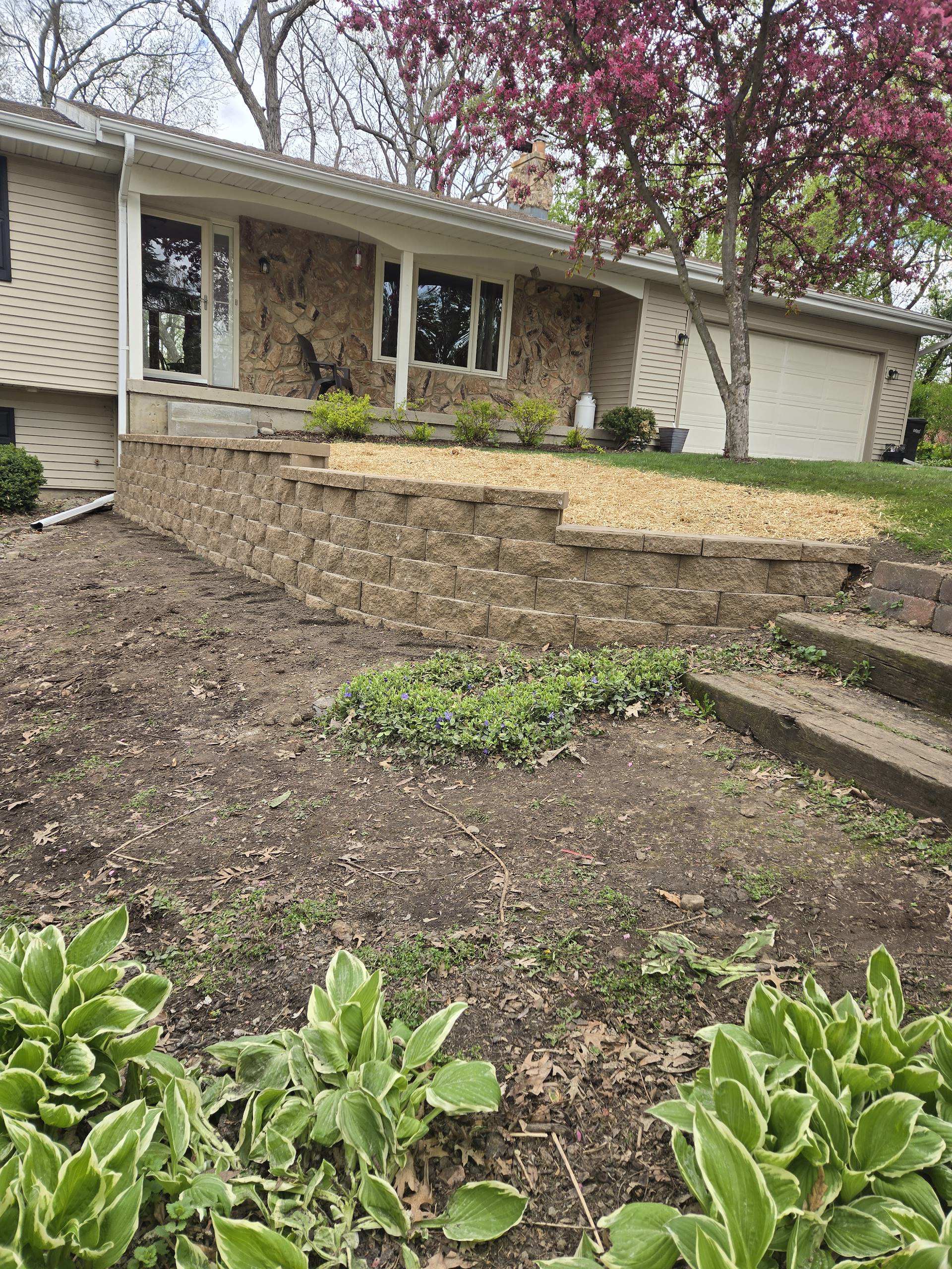 Front yard block retaining wall with fresh mulch landscaping in Dane County, WI