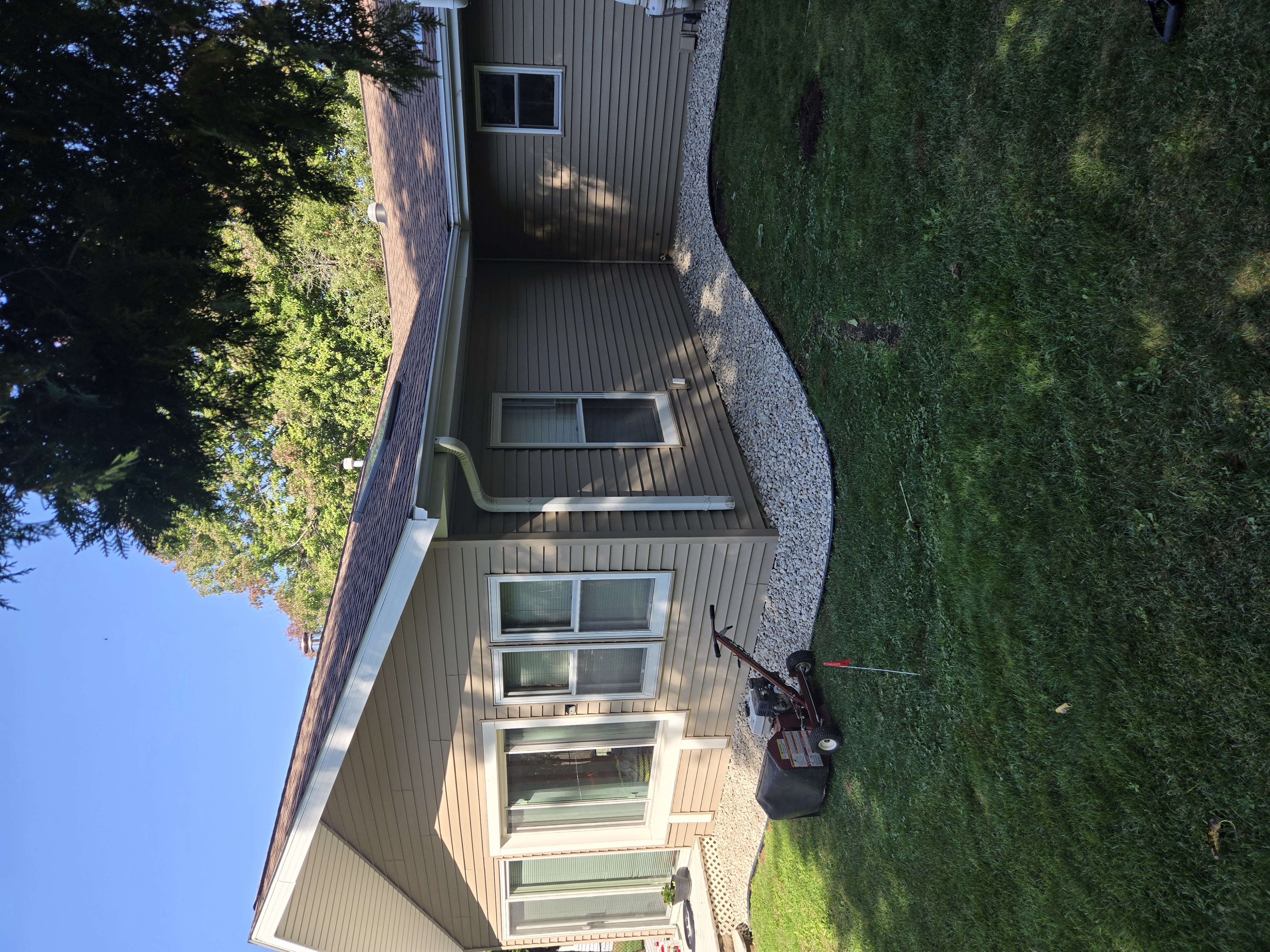 Clean rock border landscaping bed installation along house siding in Sun Prairie, WI