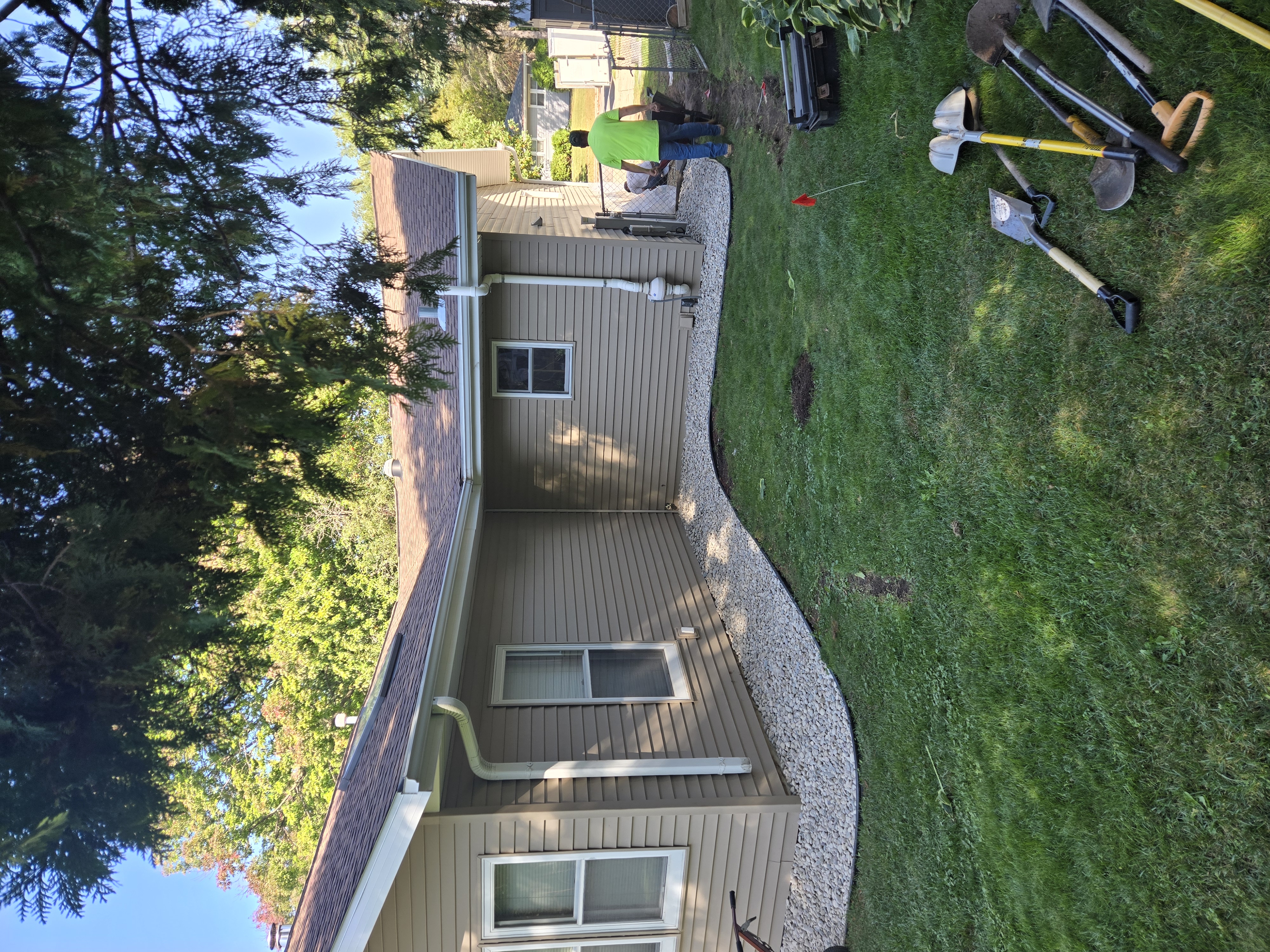 Extreme Lawns team preparing and installing stone landscape border around home in Dane County, WI