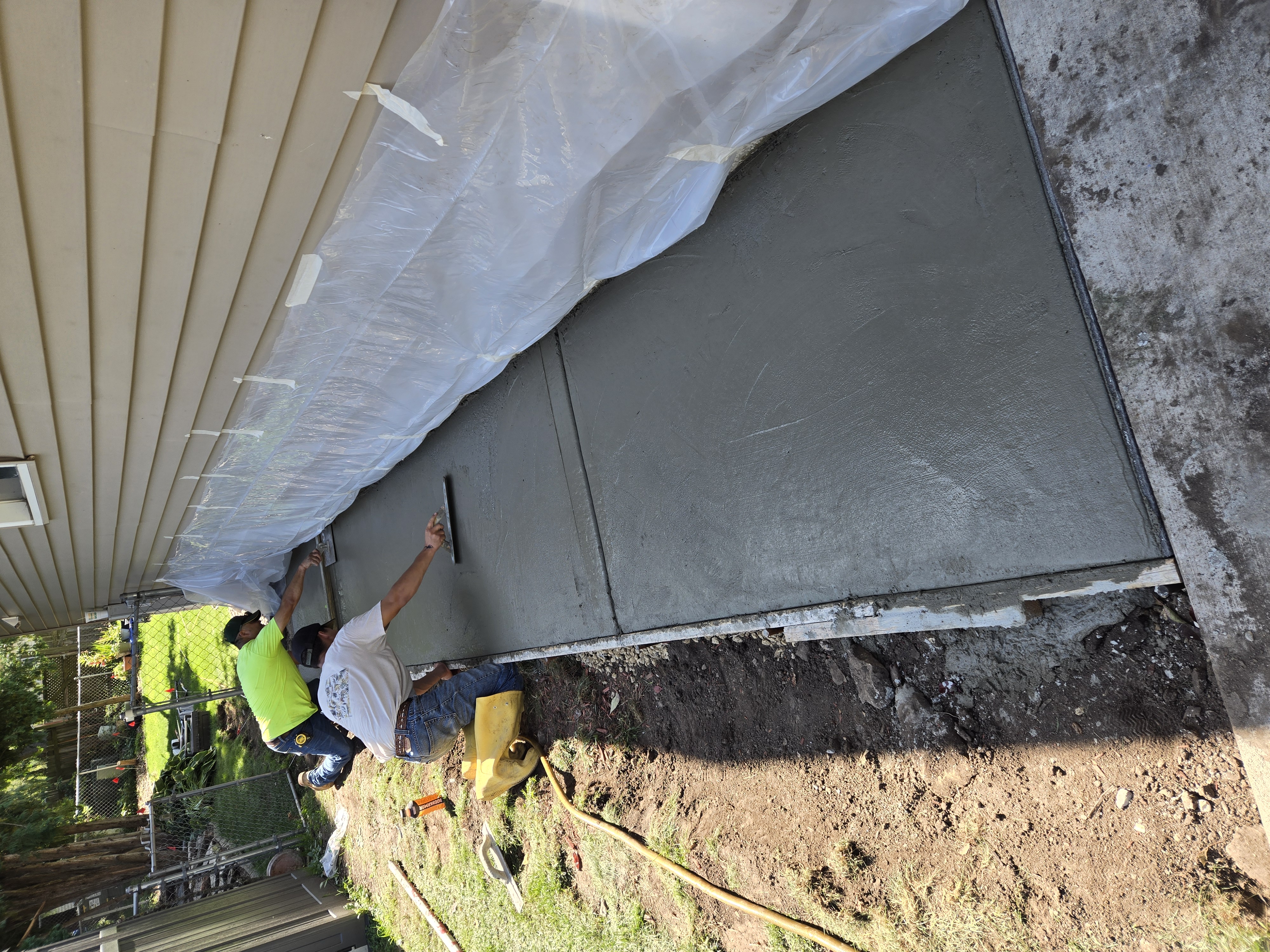 Extreme Lawns crew laying and leveling fresh concrete patio section in Dane County, WI