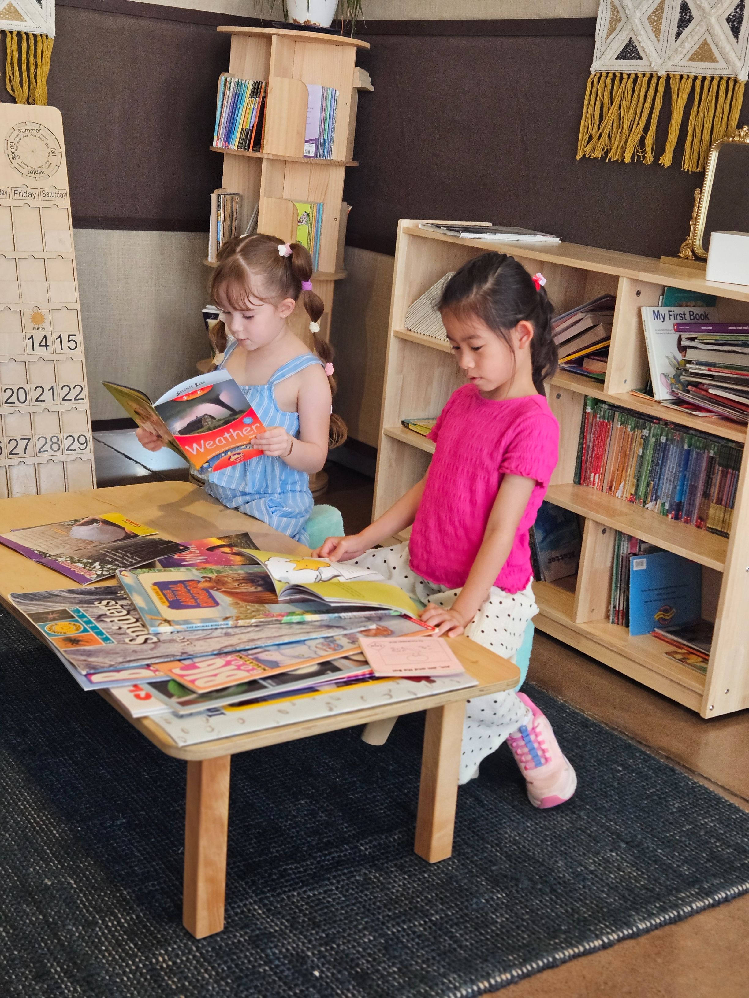 Students reading books together in the classroom library