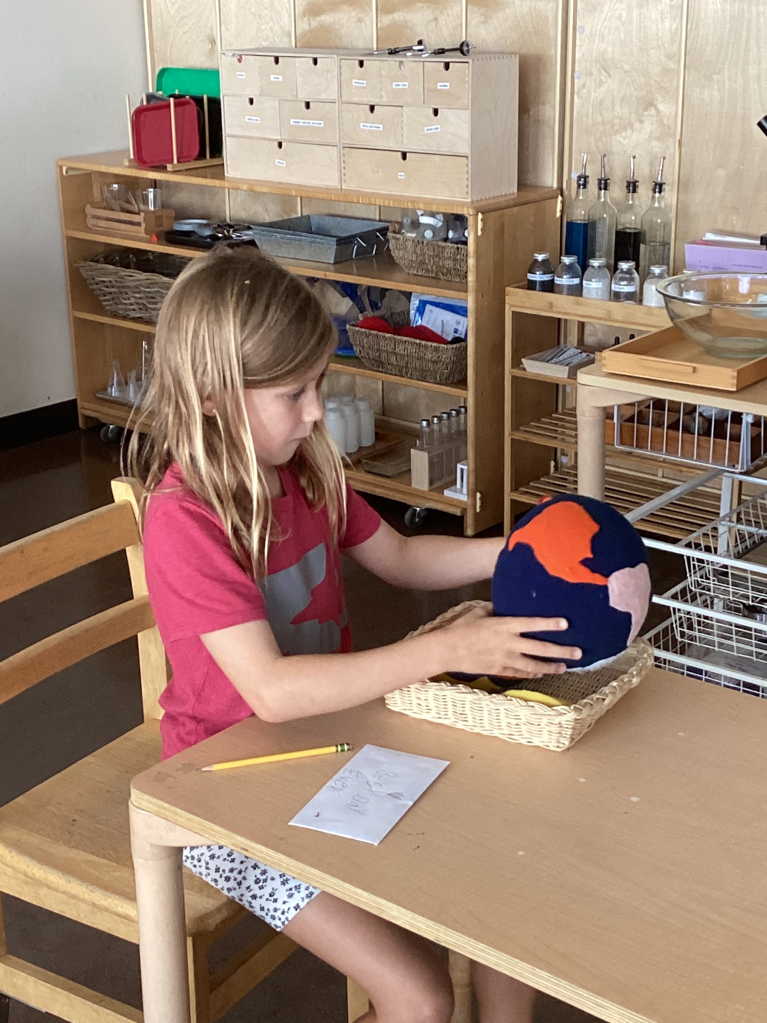 An Elementary student exploring geography with a continent globe model