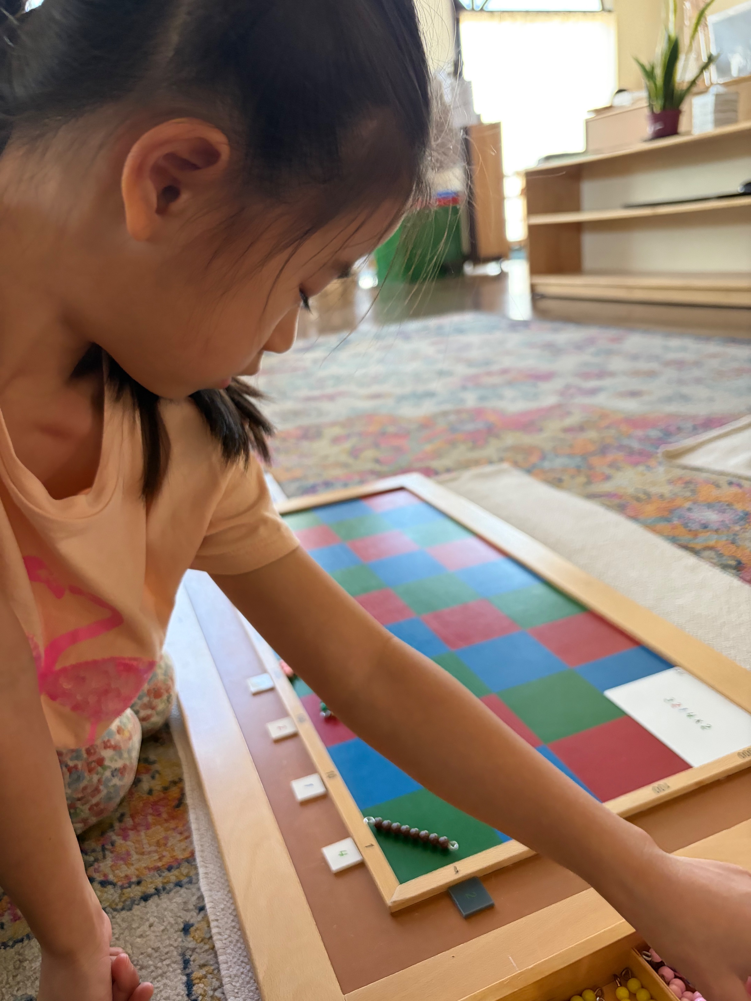 A student working with the Montessori checkerboard for long multiplication
