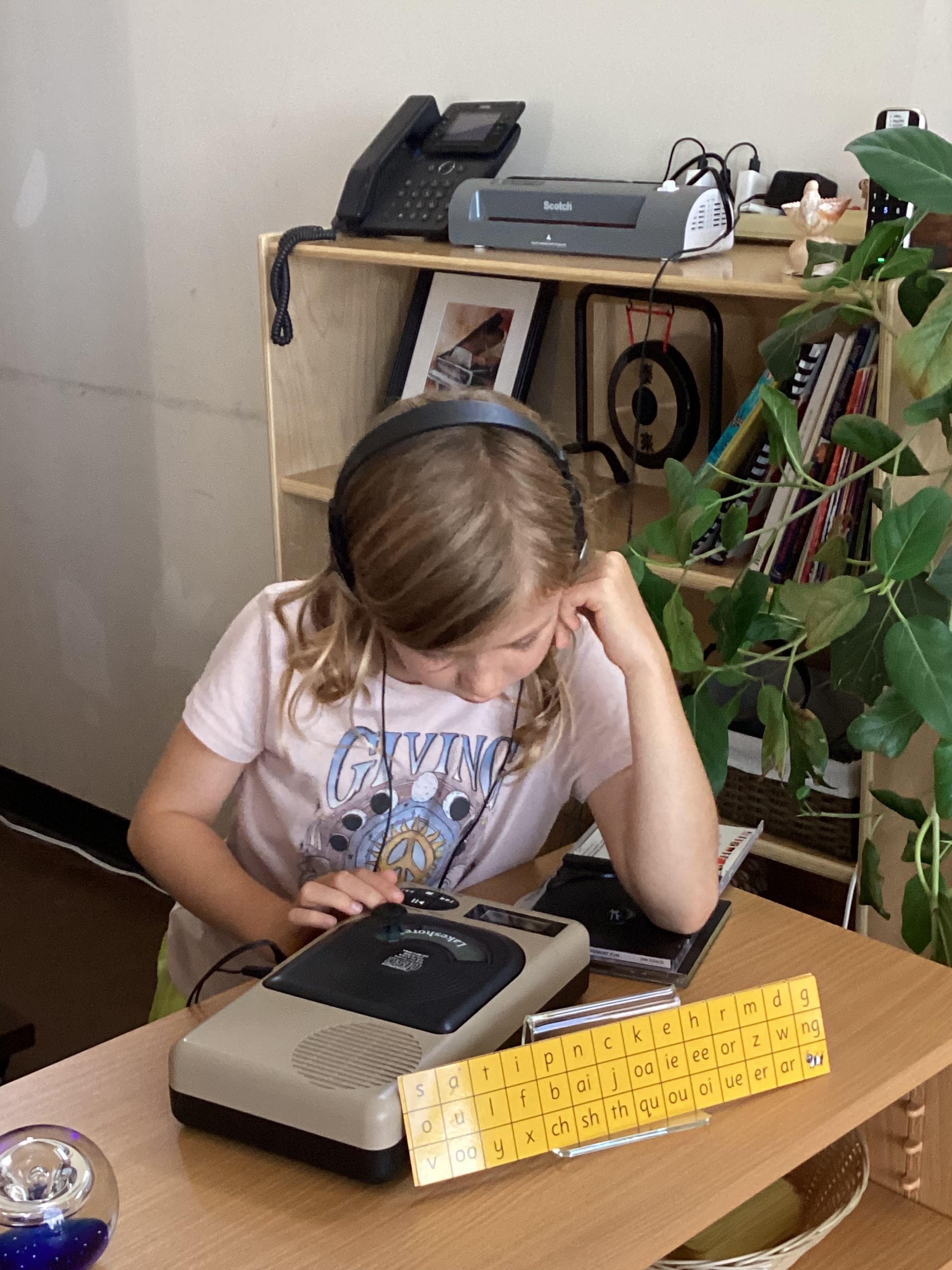 A student using the audio listening center for phonics and reading practice