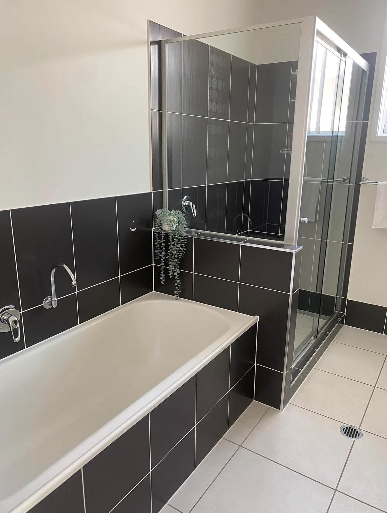 Bathroom with dark tiles and bathtub