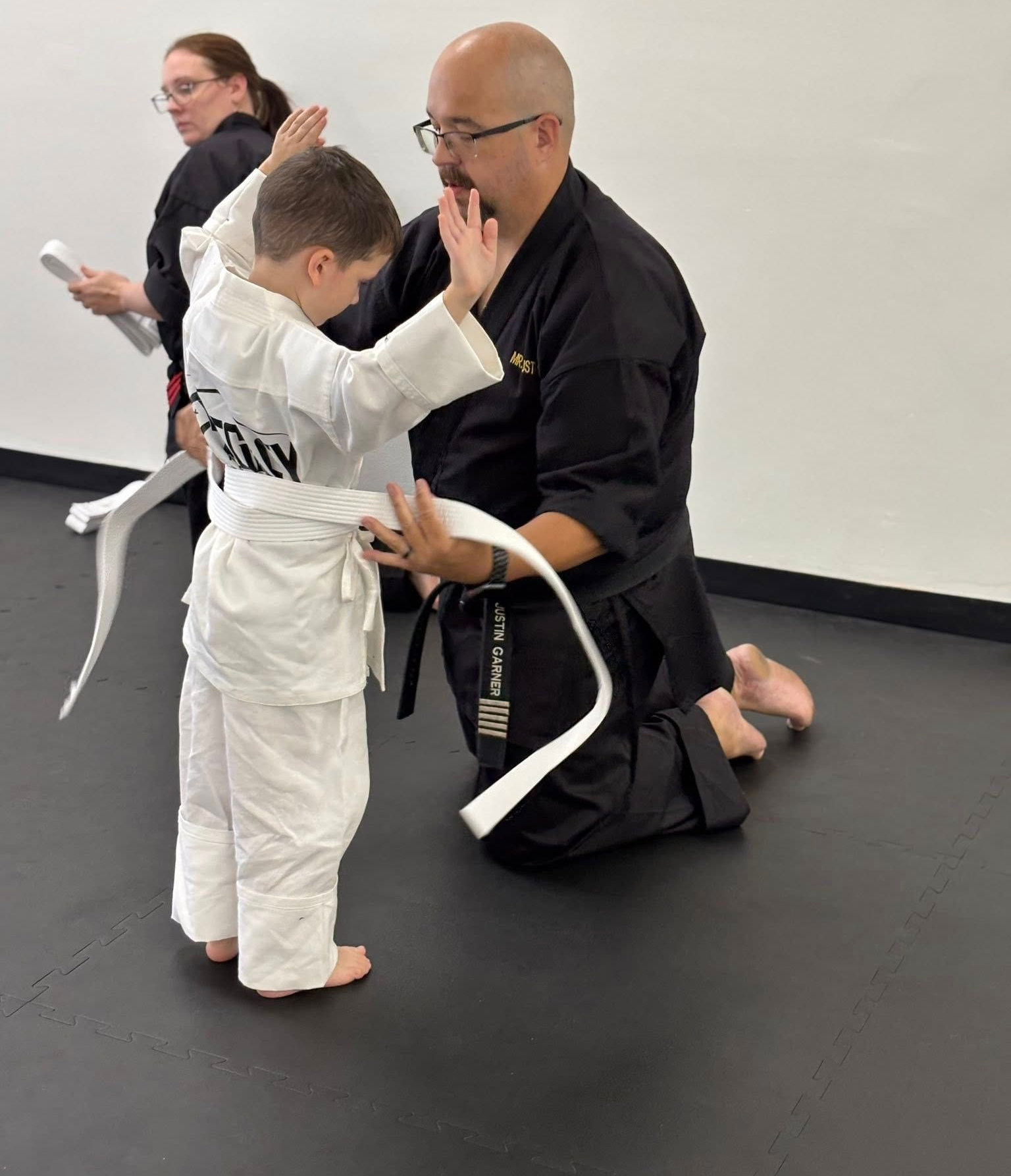 Instructor helping a child in a karate class