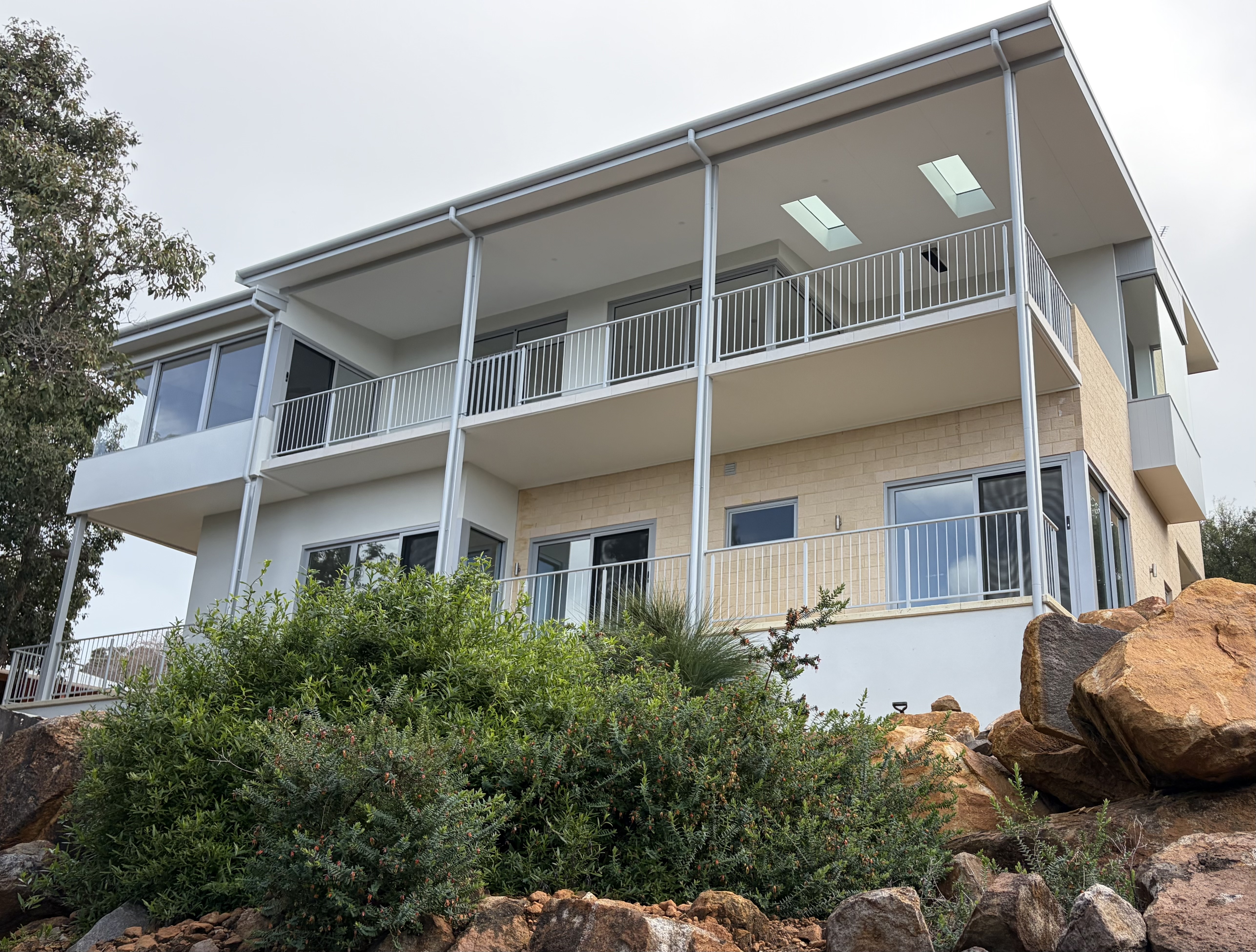 Eagle Bay Panoramic two-storey residence with feature stone wall and terraced rock landscaping