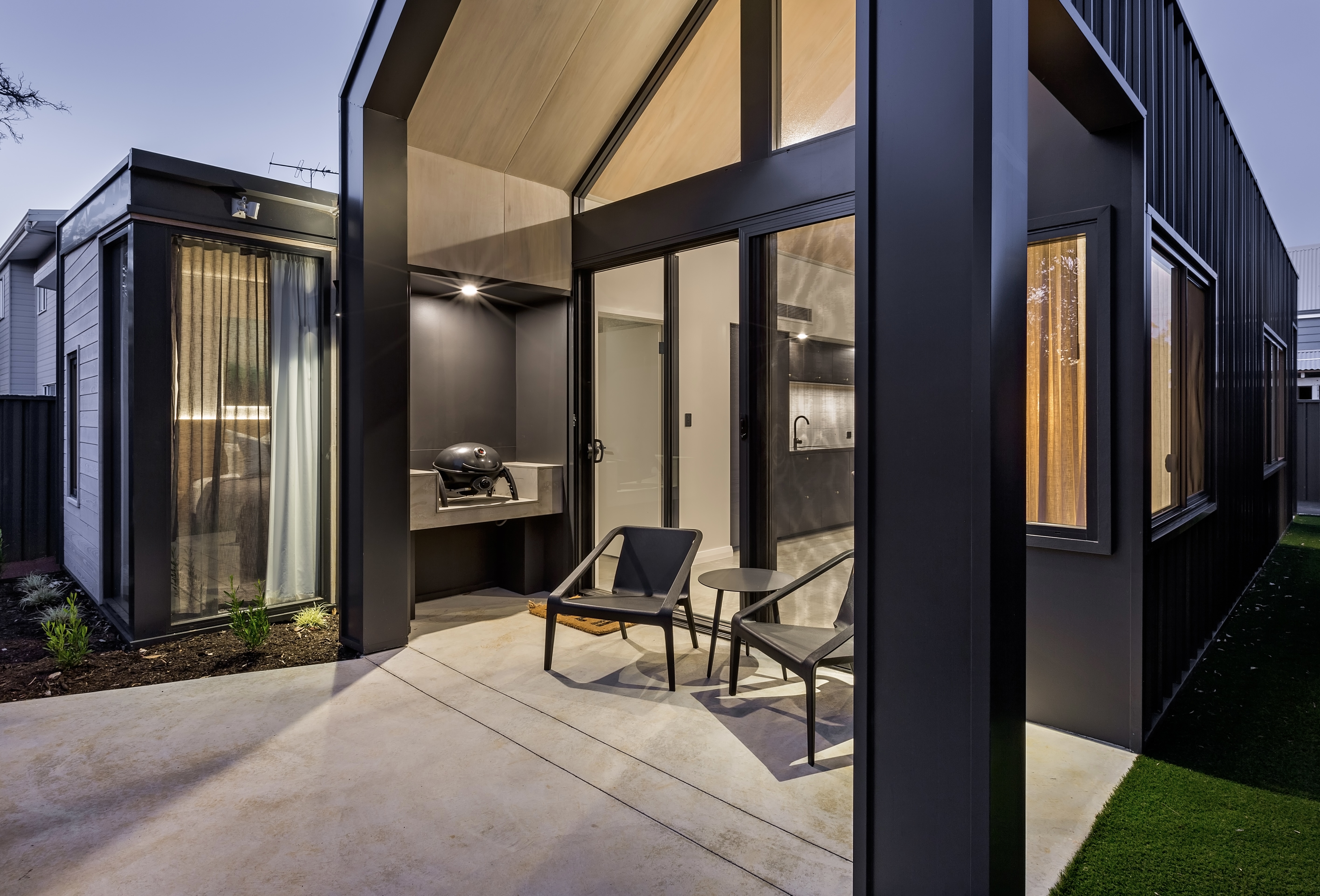 Covered outdoor alfresco deck with built-in BBQ and seating