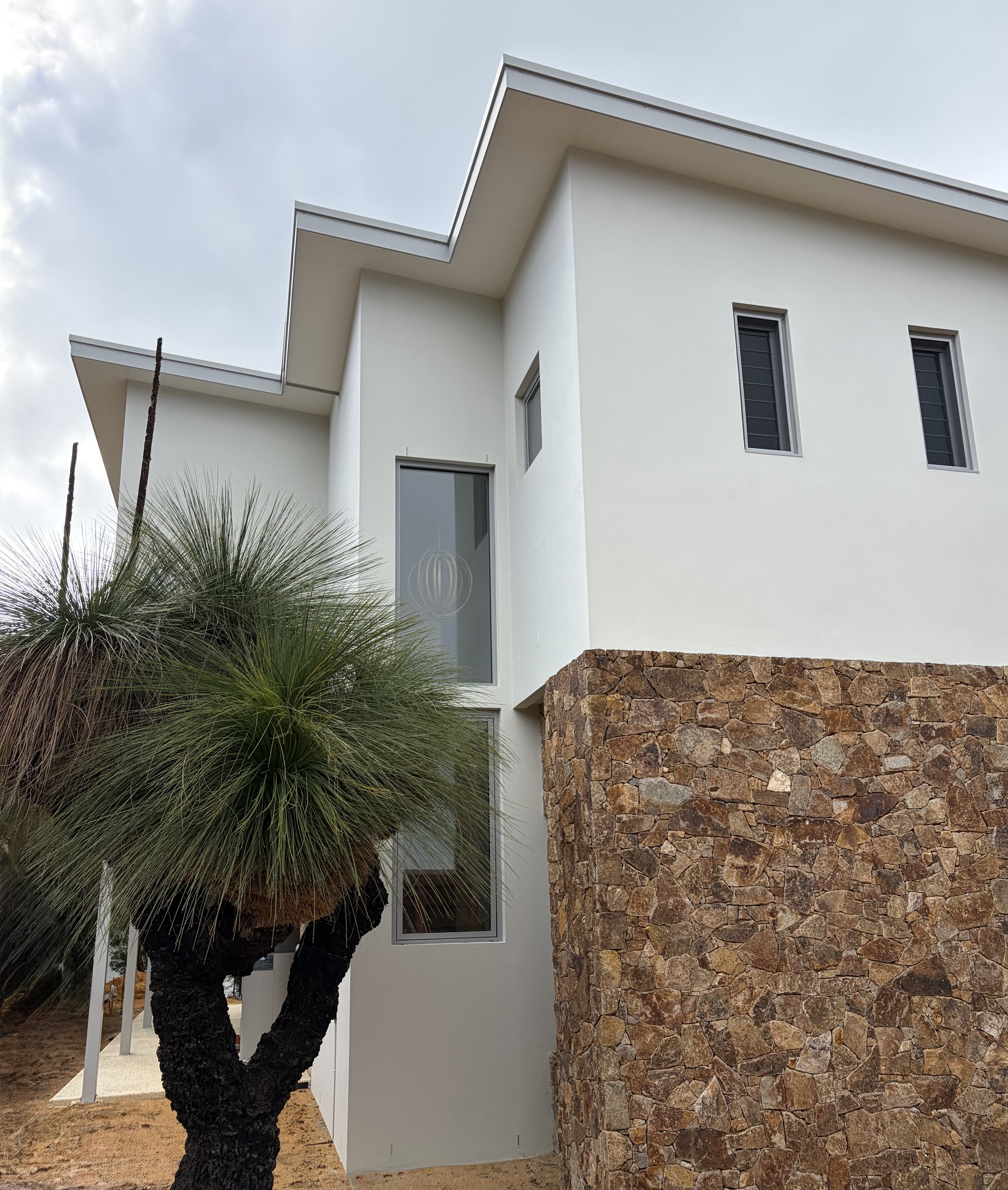 Feature stone cladding and grass tree detailing at entry
