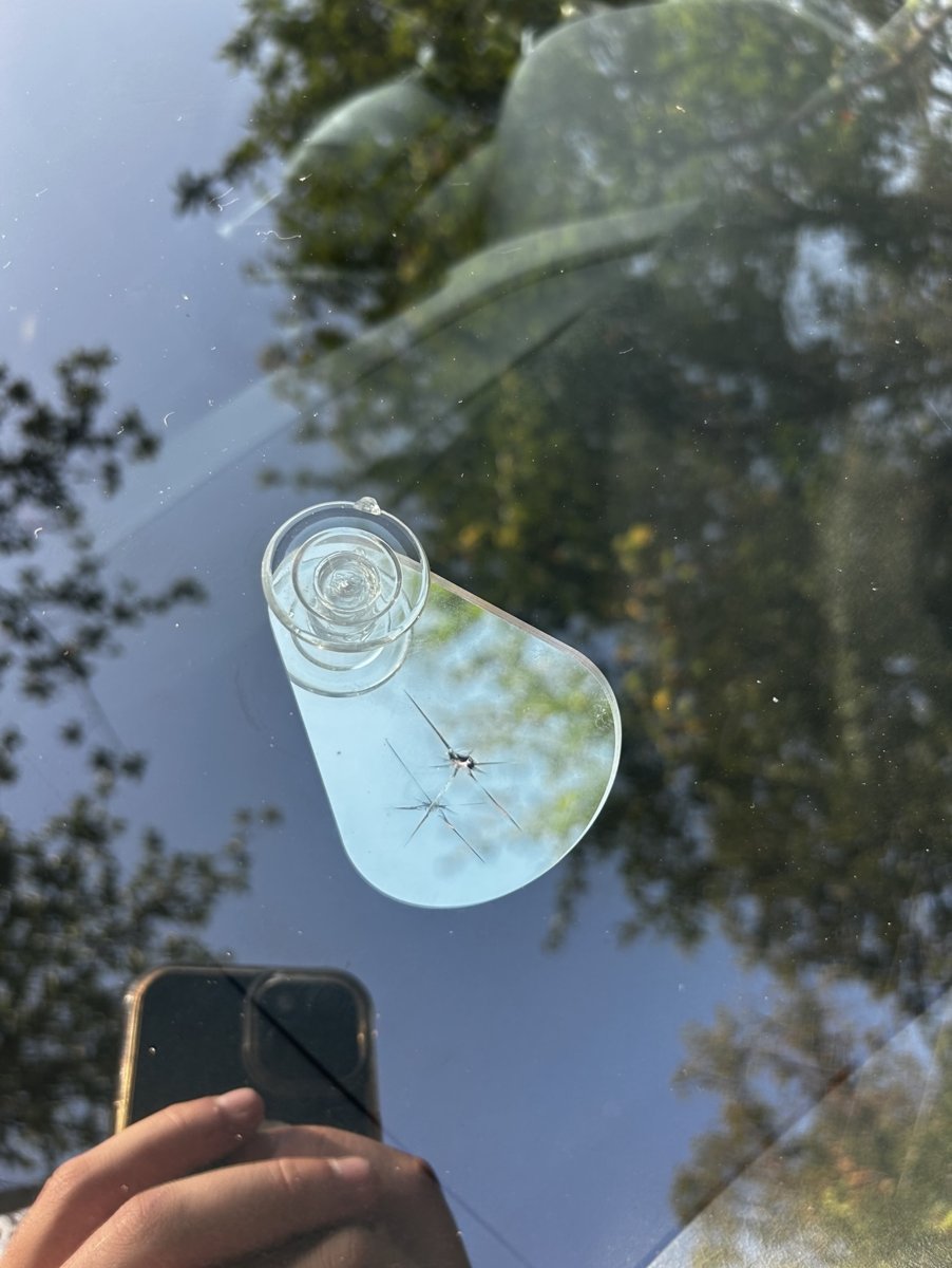 Damaged windshield glass with rock chip before repair