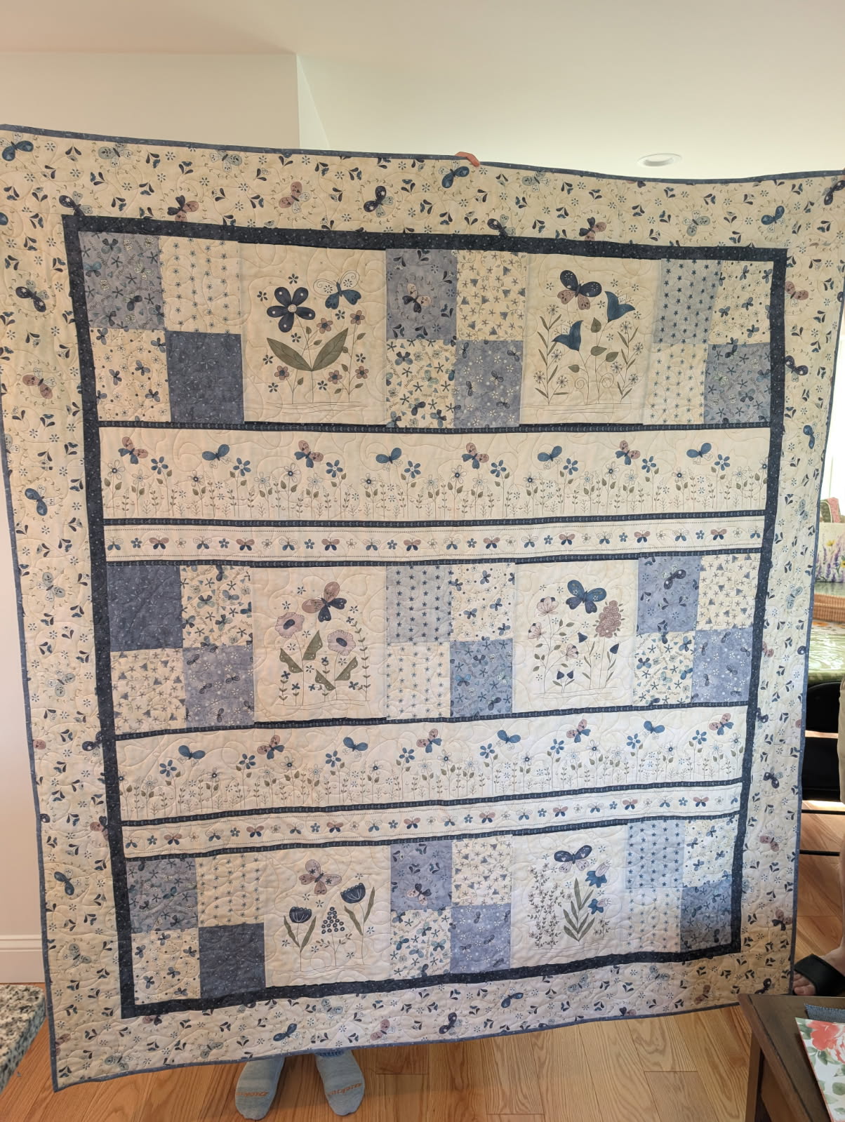 Blue and cream quilt with floral and butterfly print panels