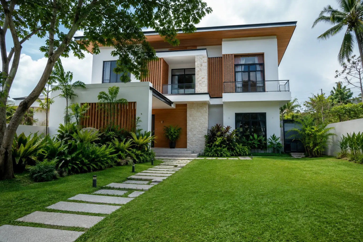Tropical Modern House Design by GAS Design & Build Cebu with White Facade Wooden Accents and Lush Garden