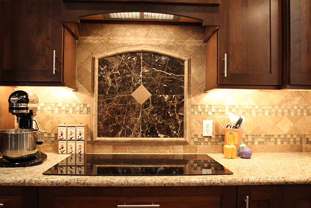 Decorative arched stone and marble backsplash feature behind cooktop