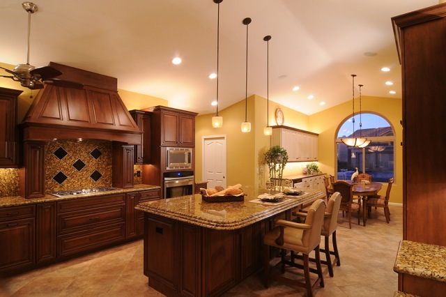 Kitchen looking through to formal dining area with arched window and chandelier