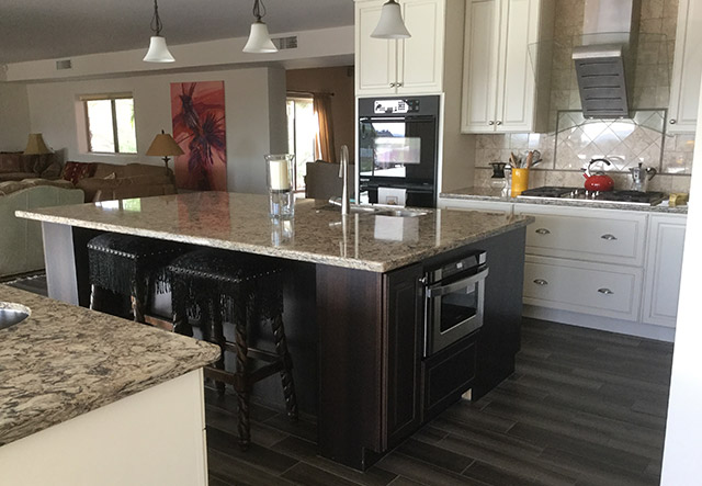 Center island with granite countertop, microwave drawer, and view toward living room