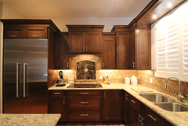 Staggered wood cabinetry with decorative tile backsplash and cooktop