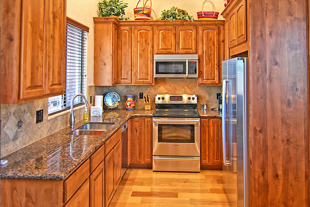 Full casita kitchen with warm wood cabinetry and granite countertops