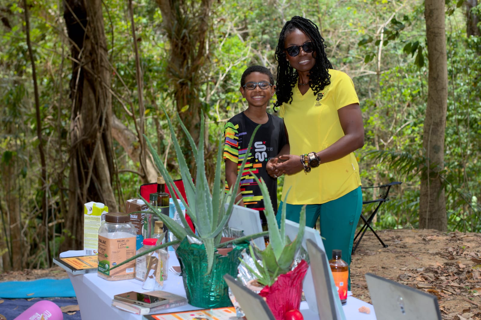 Natural wellness educator with aloe vera plants and holistic products