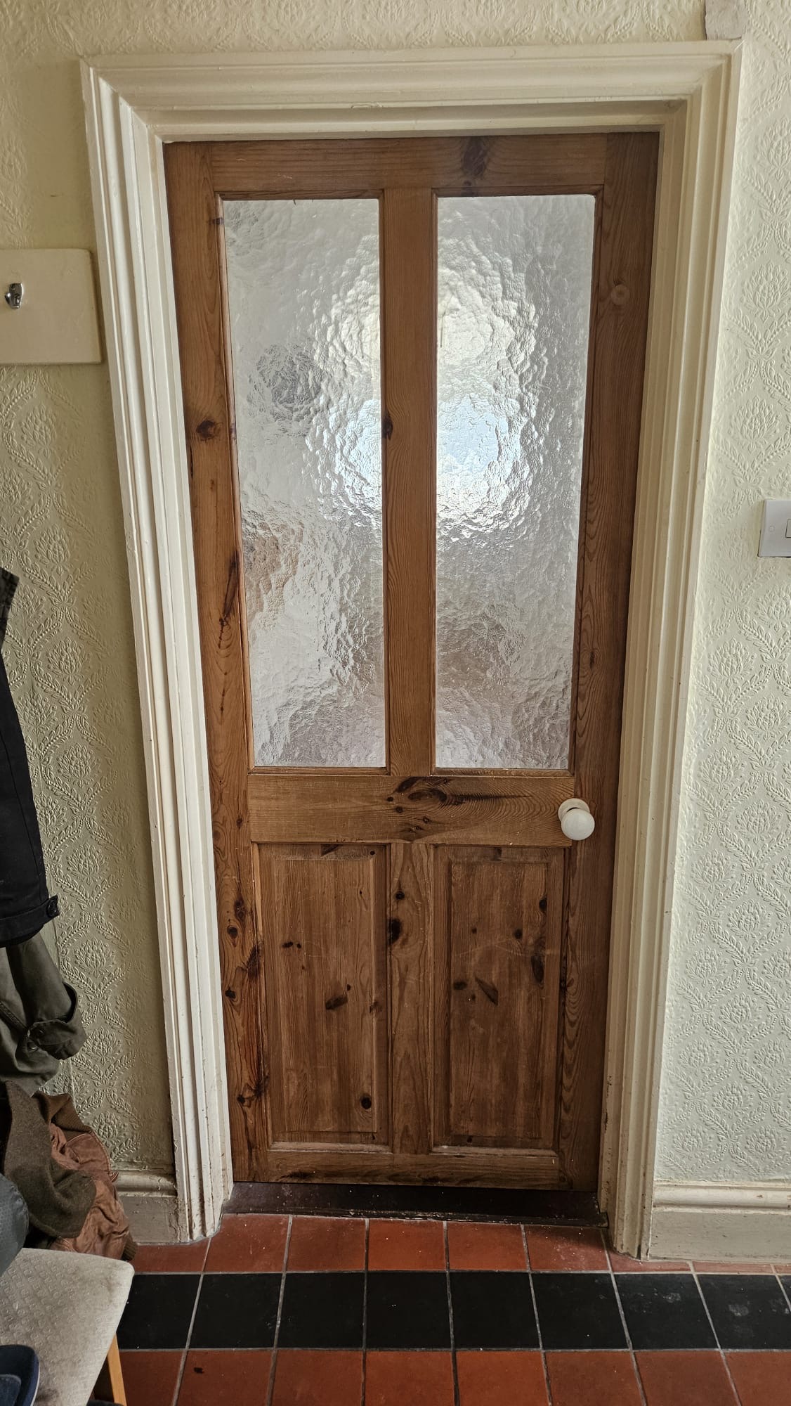 BEFORE — Original Victorian-era glazed timber door with twin textured glass panels, raised mouldings and porcelain knob handle showing age-related wear requiring full remediation or replacement