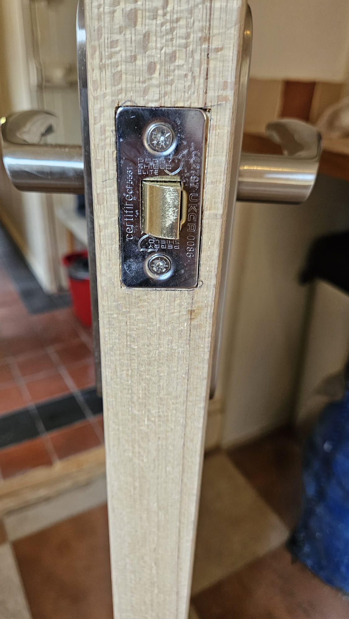 Close-up of newly installed CE2797 UKCA certified fire-rated lock body fitted to remediated timber door leaf with precision-cut lipping