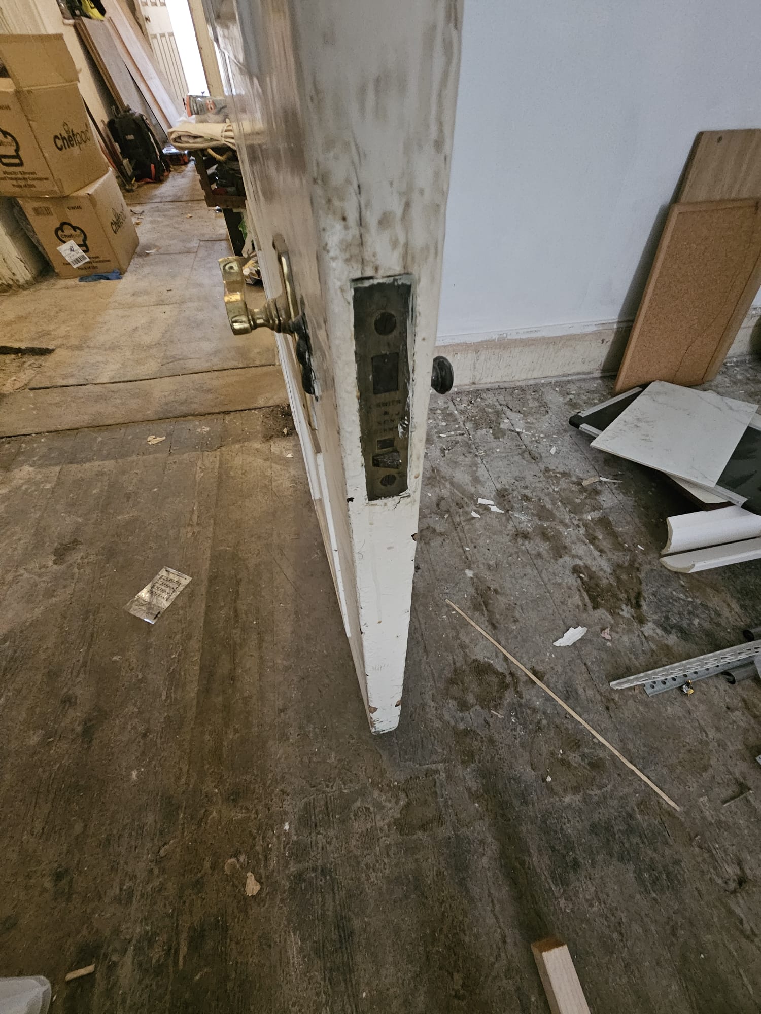 Close-up of original Victorian door leaf showing period ironmongery, lock body and door handle before remediation works