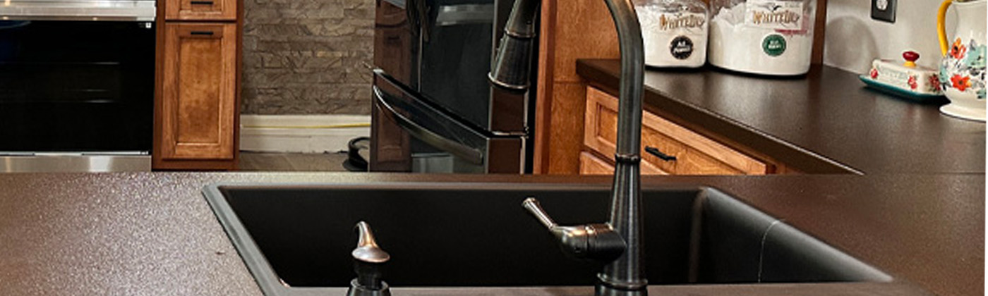 Custom powder-coated metal kitchen countertop with dark sink and faucet
