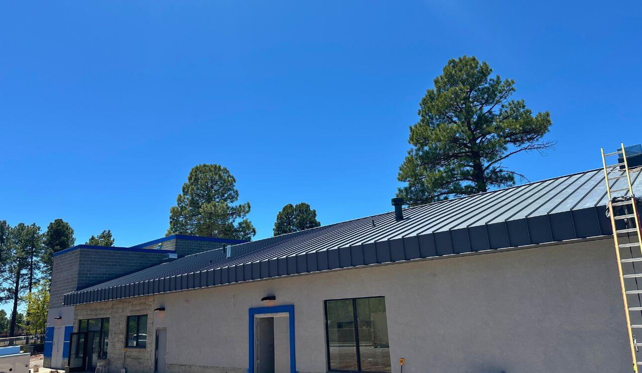 Commercial standing seam metal roof in Northern Arizona with dark charcoal Kynar 500 finish