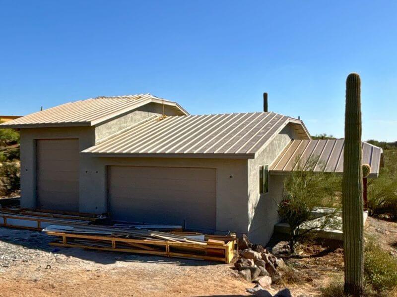 Completed standing seam metal roof installation on a Cave Creek Arizona desert home showing finished light gray panels