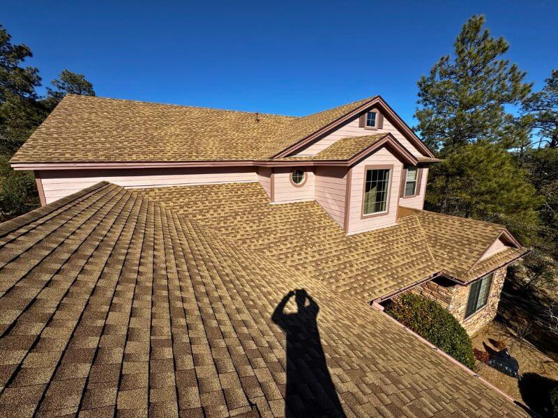 Completed tan GAF Timberline HDZ architectural shingle roof on home in Prescott Arizona with clean ridgelines
