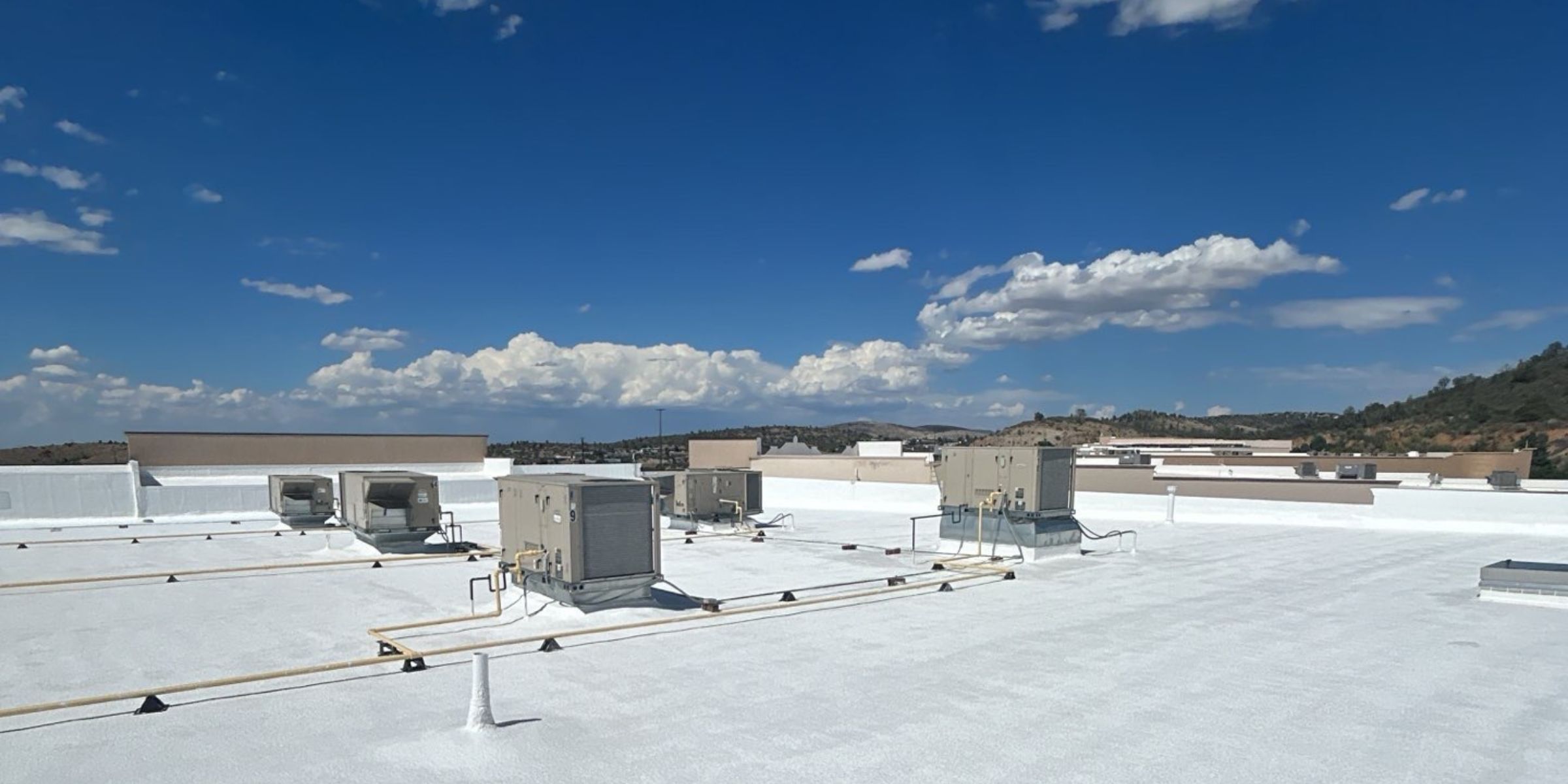 White reflective TPO flat roof with HVAC units and mountain views in Arizona