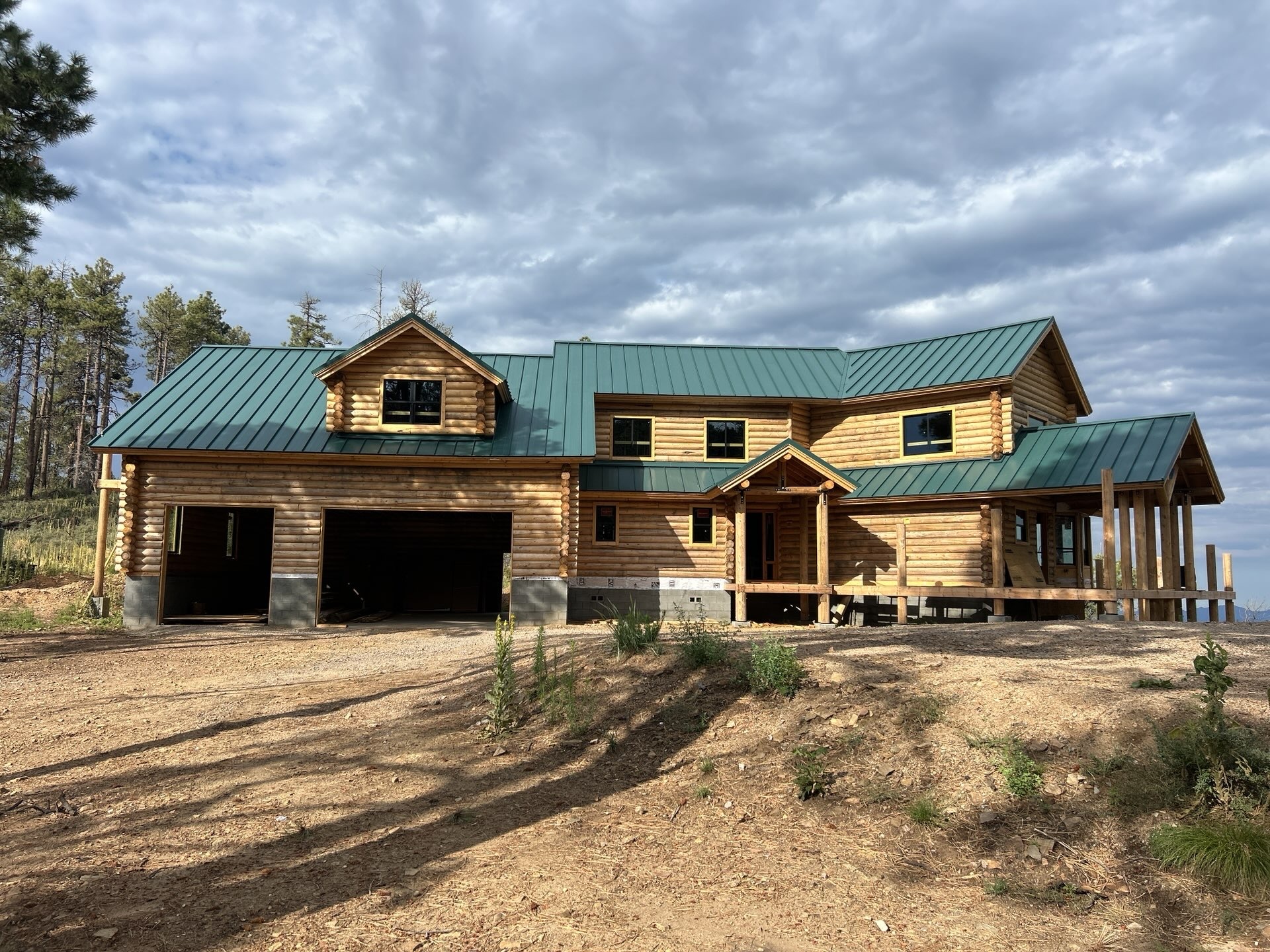 Green standing seam metal roof installation on a Prescott Arizona log cabin home built for snow and wind resistance