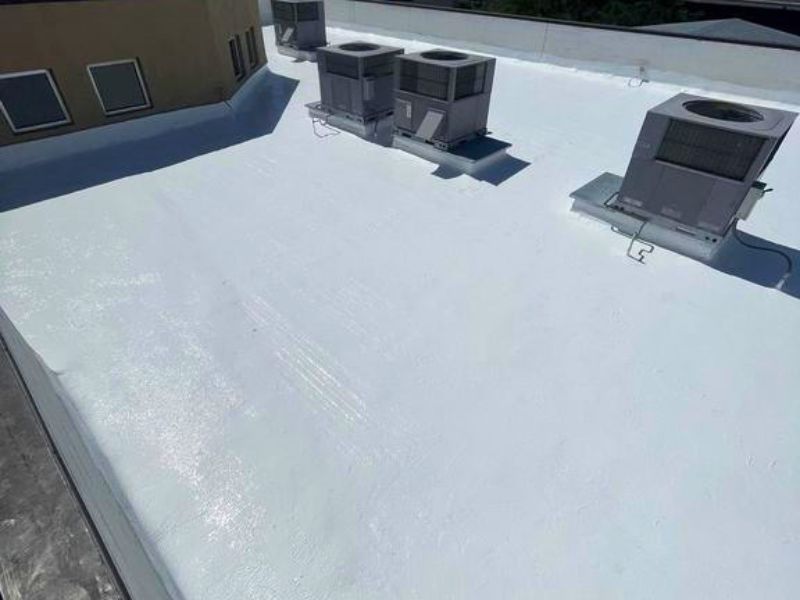 Completed silicone roof coating restoration in Anthem Arizona with bright white reflective commercial roof surface