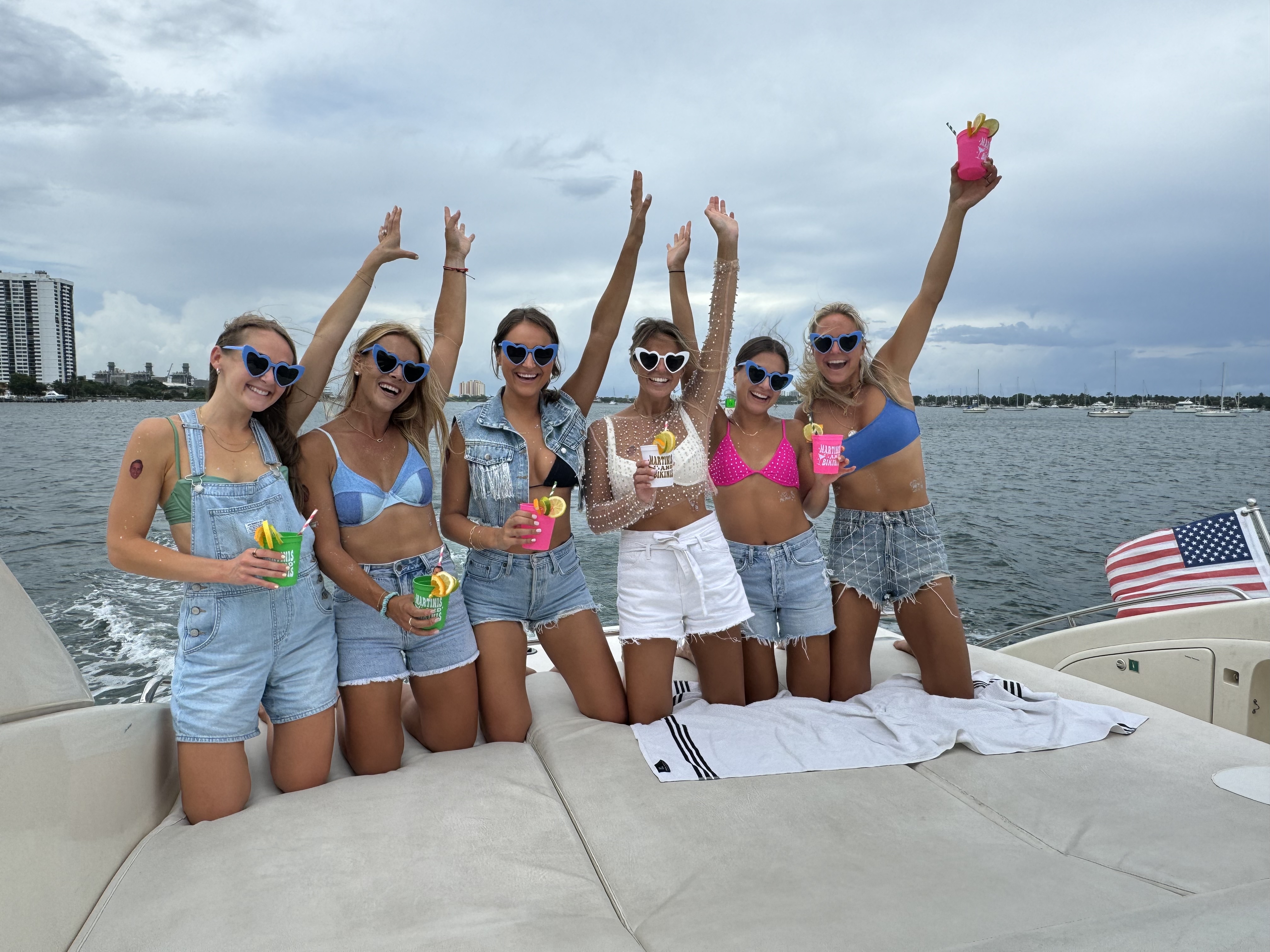Bachelorette group with heart-shaped sunglasses celebrating on private boat rental Palm Beach